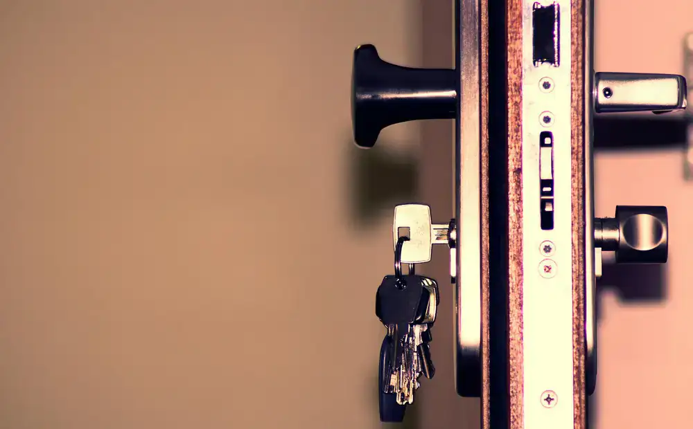 Locksmith carefully adjusting a new mortice lock on a heavy door